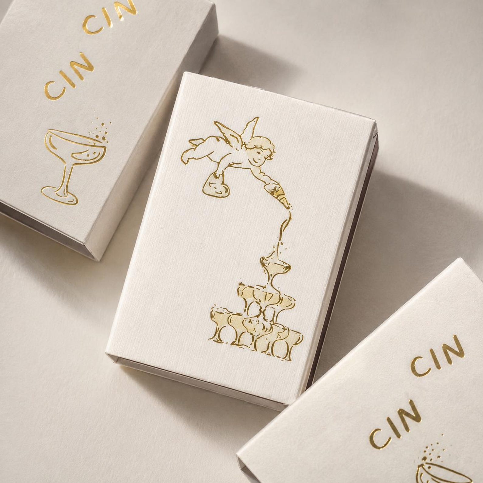 Ivory wedding matchboxes with delicate gold foil illustrations and lettering