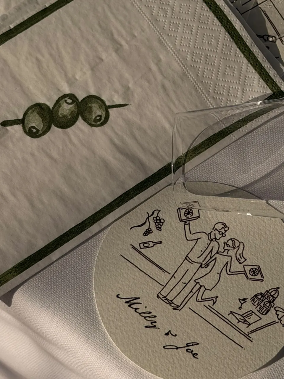 A personalised illustrated coaster arranged with olive green table linen
