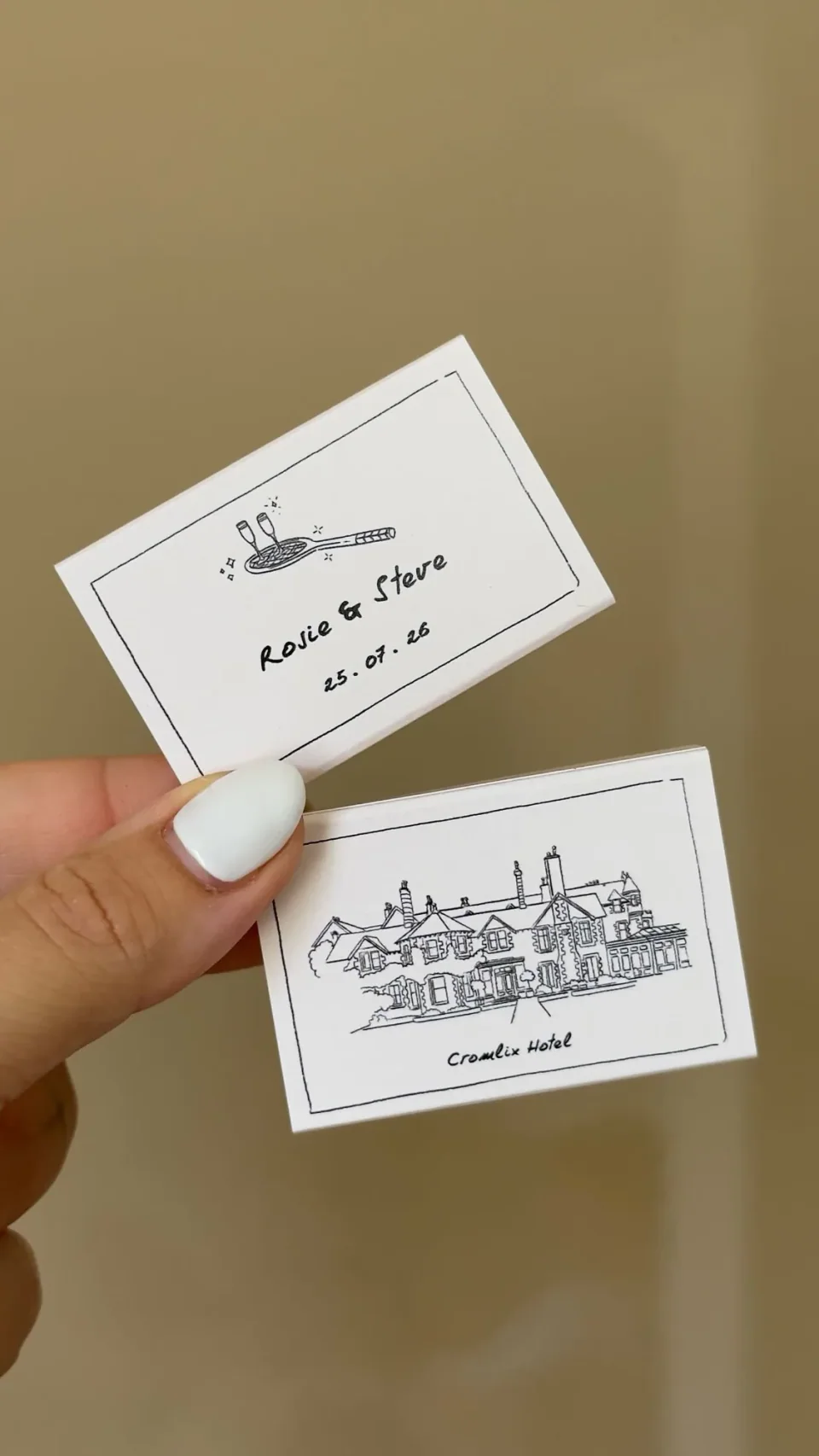 White matchboxes with a line drawing of a hotel and a tennis racket with two glasses