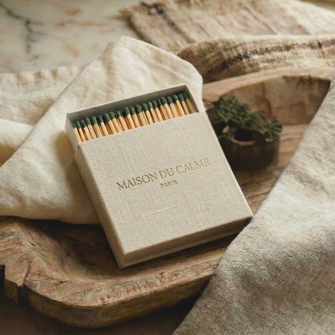 A large linen covered matchbox with long green tipped matches